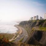 A breathtaking view of the cliffs in Miraflores, Lima with high-rise buildings and the ocean shore.