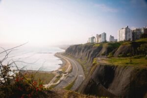 A breathtaking view of the cliffs in Miraflores, Lima with high-rise buildings and the ocean shore.