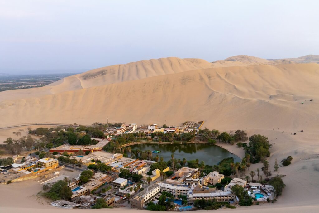 A breathtaking aerial view of the Huacachina oasis surrounded by sand dunes in Ica, Peru.