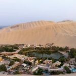 A breathtaking aerial view of the Huacachina oasis surrounded by sand dunes in Ica, Peru.